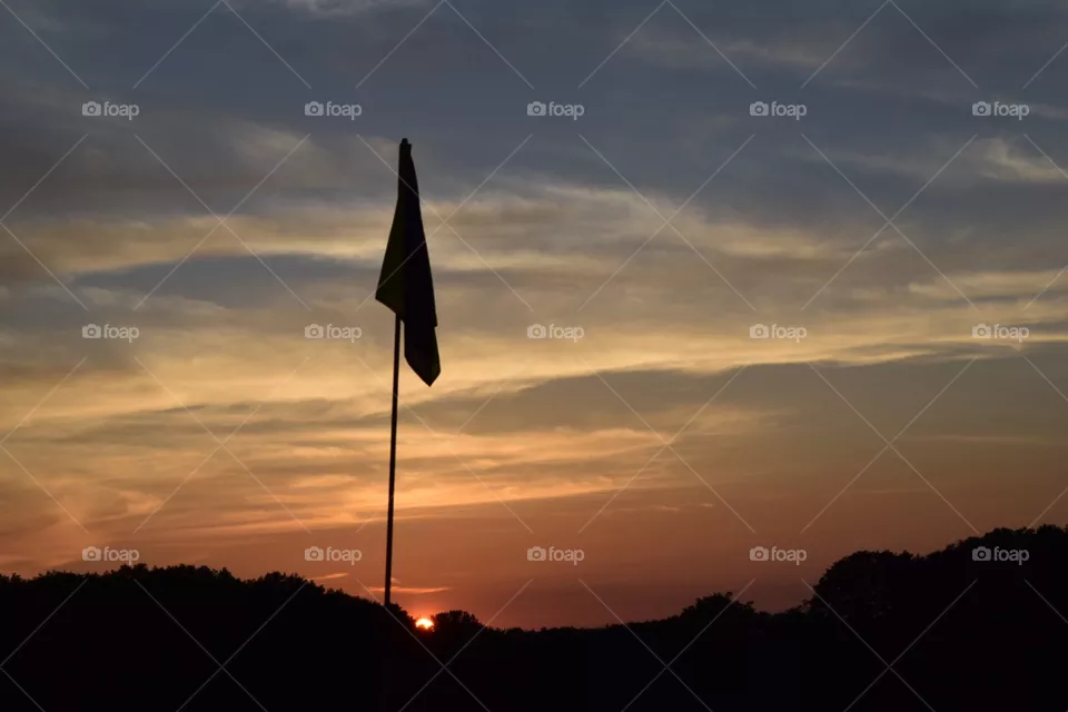 Golf pin at sunset.