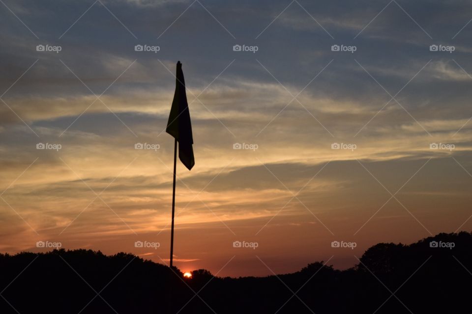 Golf pin at sunset.