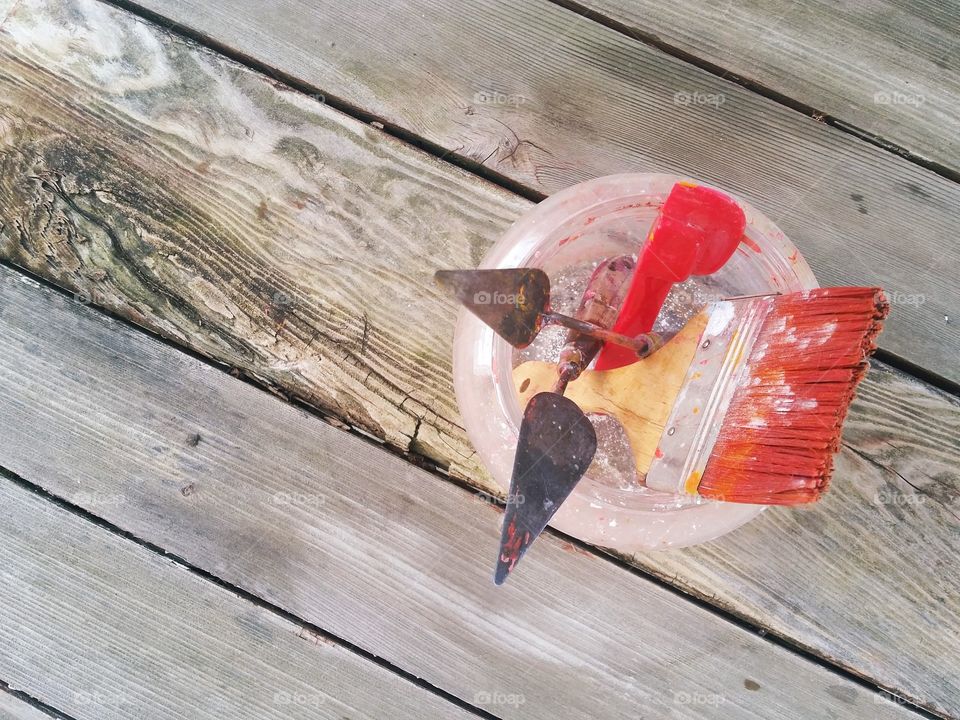 Overhead view of well used glass jar holding artist's tools