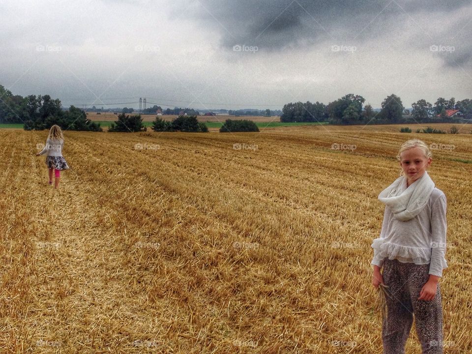 Two sisters standing on agriculture field