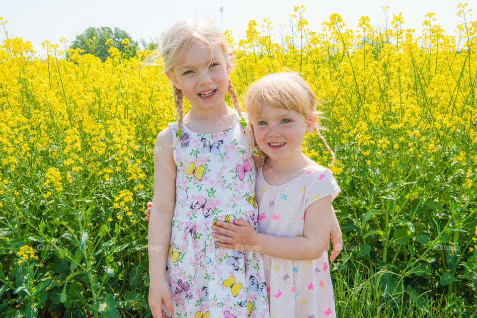Portrait of two smiling sisters in field