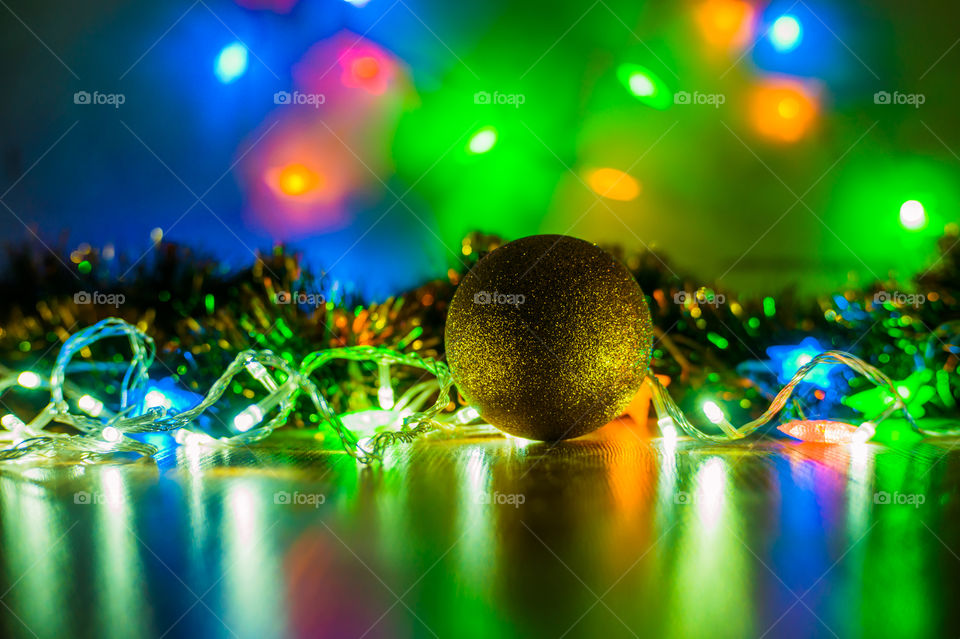 Christmas ball among flashing garlands in December