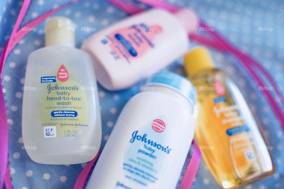 Johnson and Johnson baby products on a blue and white polkadot background with a pink ribbon Flatlay 