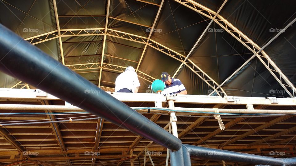 Homens com sorteio de bingo no palco.