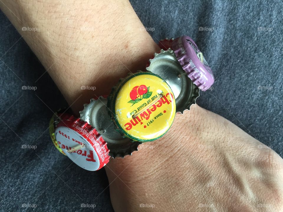 This bracelet is made with bottle caps; vintage soda caps on one side, and it can be flipped over to show Coke bottle caps. 