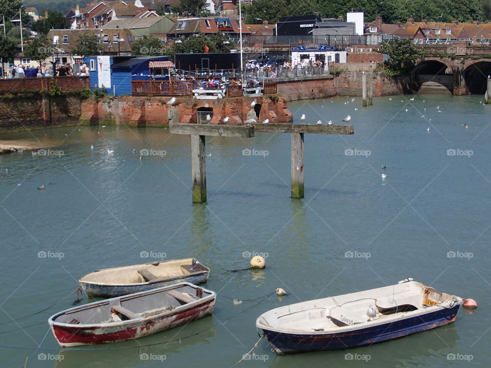 Old wooden boats in the harbor in the coastal town of Folkestone in England on a sunny summer day. 
