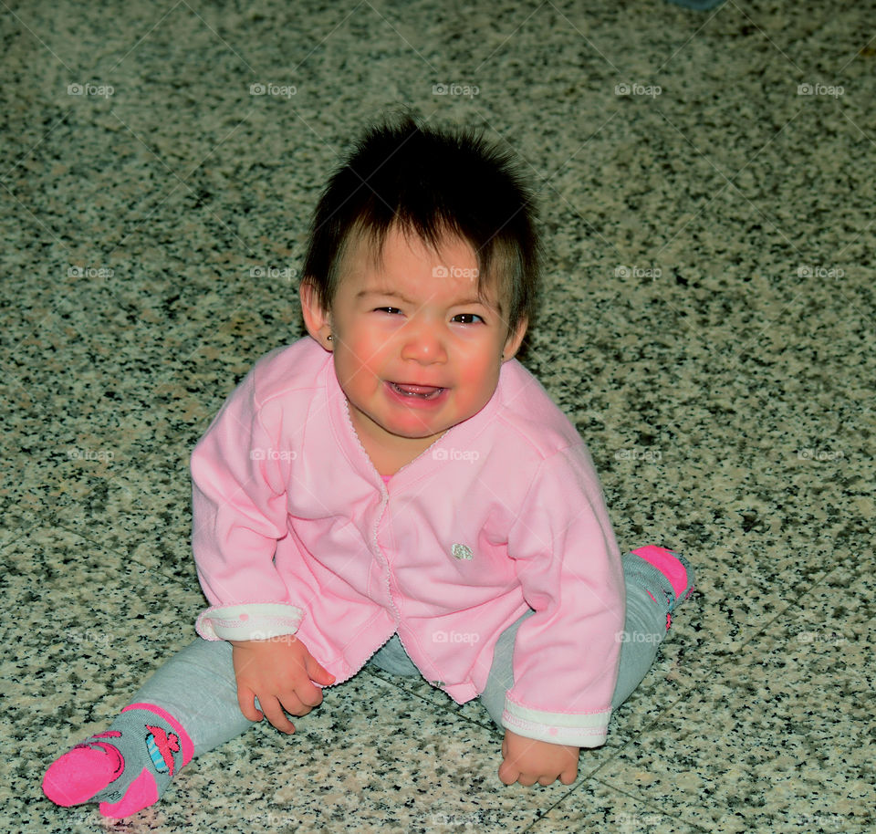 Portrait of a crying boy sitting on floor