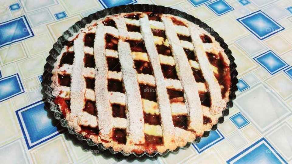 homemade cherry tart on a square-pattern tablecloth