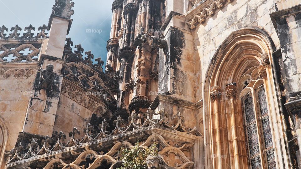 Batalha, Portugal - September 1, 2024: The Batalha Monastery, a stunning example of Gothic architecture, stands majestically under a bright blue sky. This UNESCO World Heritage site is renowned for its intricate design and historical significance.