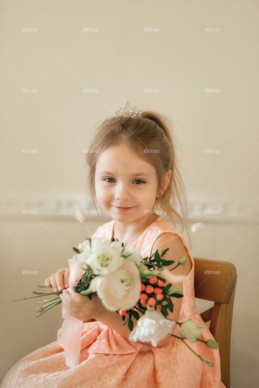 Birthday portrait of a beautiful little girl with bouquet 