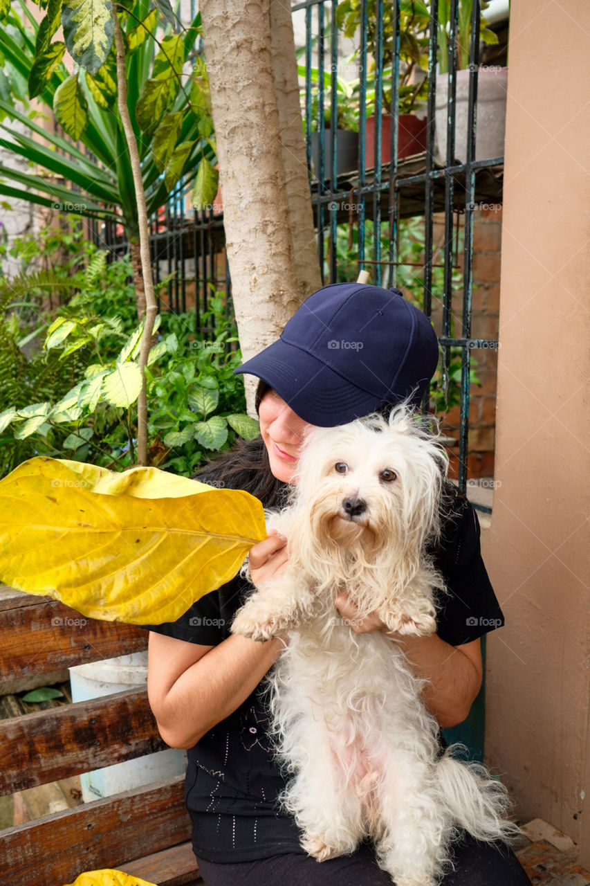 Girl petting her white dog, shows tenderness and happiness