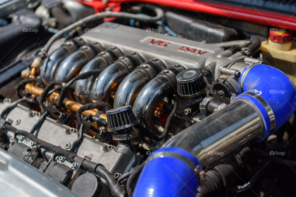 Close-up of an alfa romeo v6 engine with shiny chrome parts