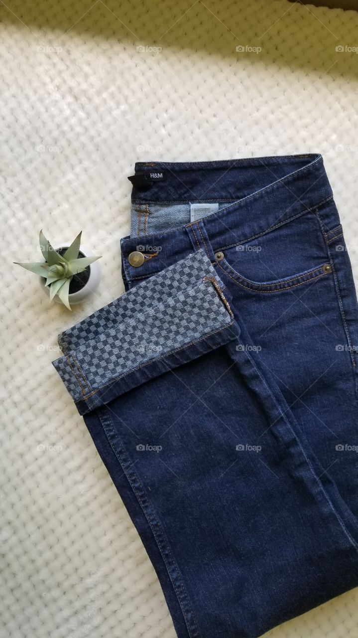 Simple Flat Lay for Blue Jeans with checkered pattern cuff at the bottom.