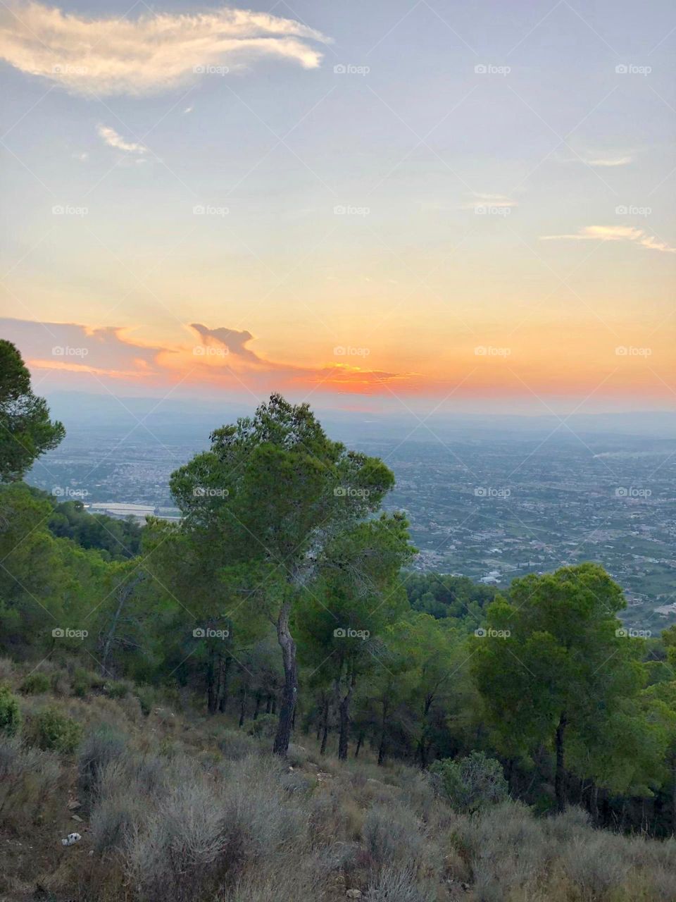 A beautiful sunset from the top of the mountain. From above you can see part of the city.