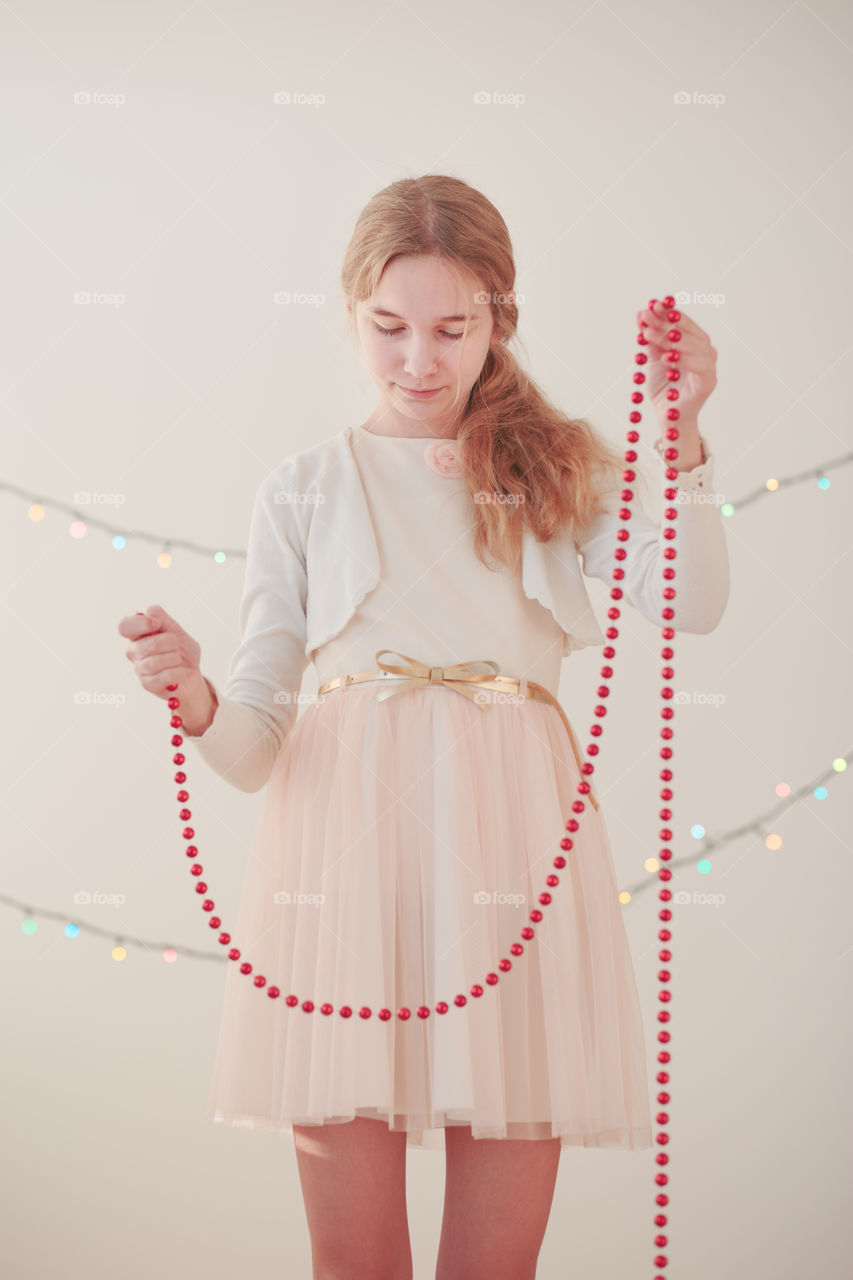 Young girl holding Christmas string ornament