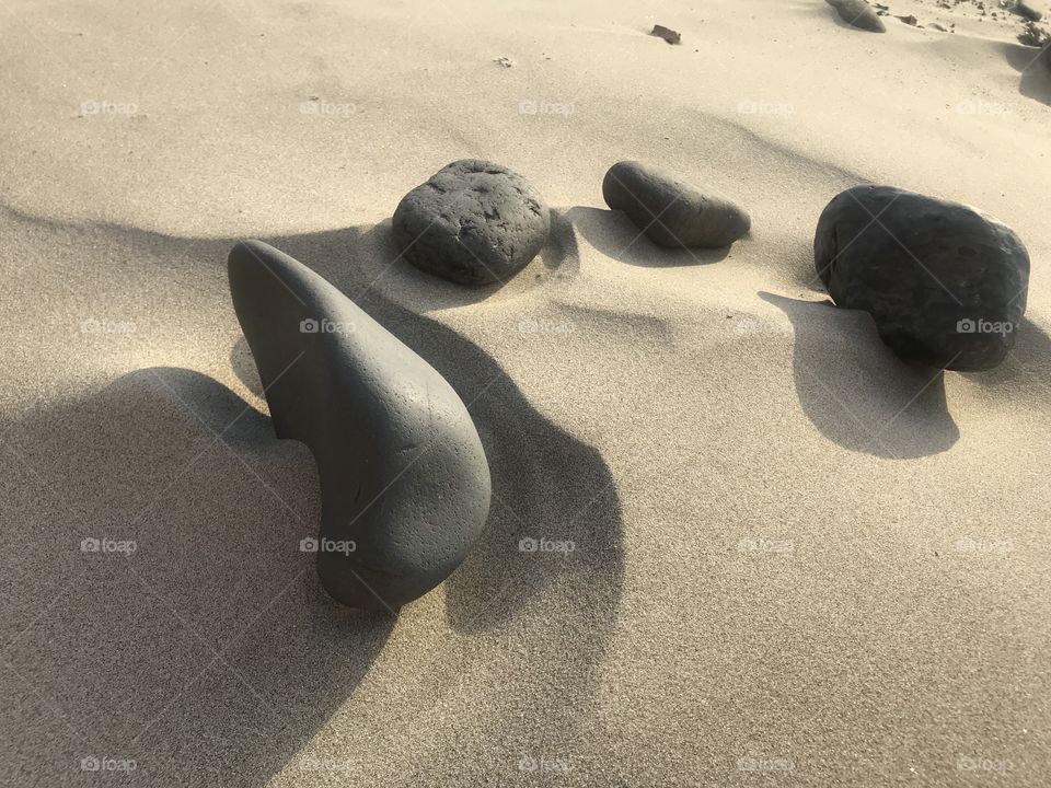 Shadow light rocks on sandy beach