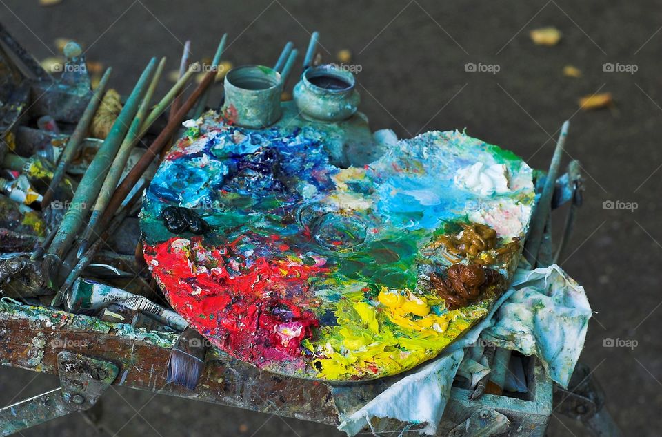 Board that provides a flat surface on which artists mix paints and the range of colors used