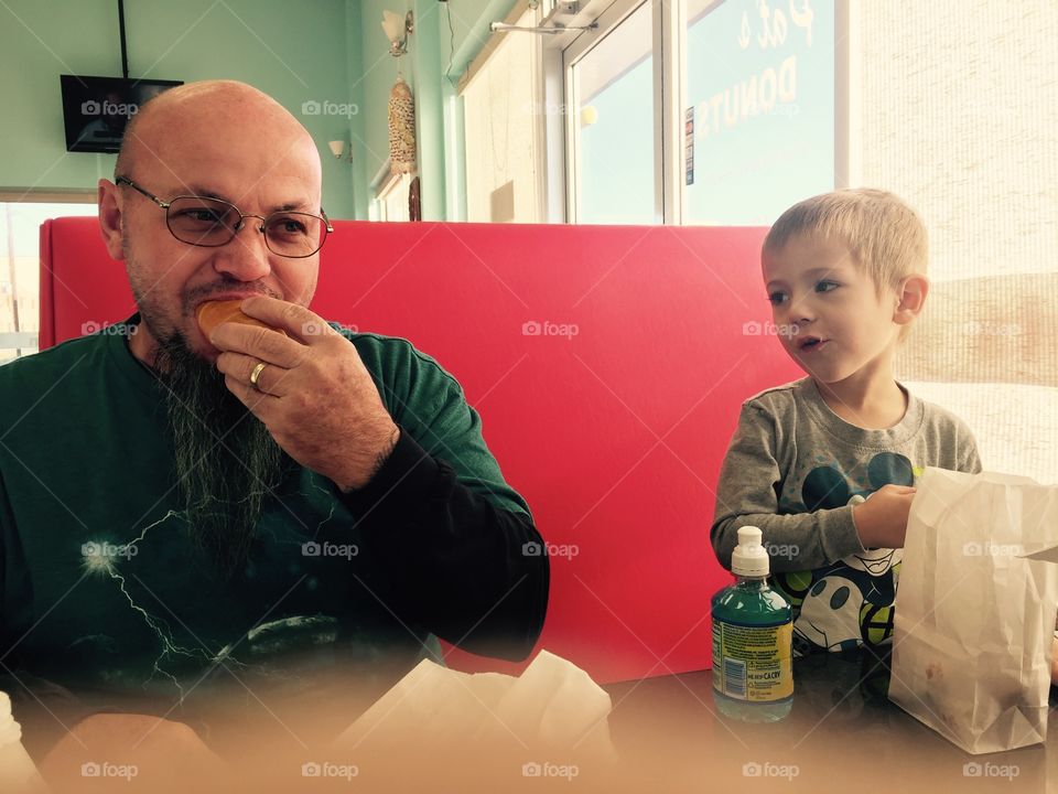 Pawpaw and grandson eating donuts together 