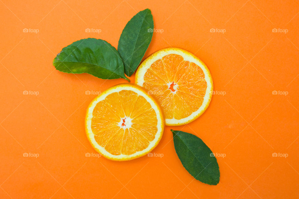 Circle! Image of two sliced oranges forming circles on Orange  background and green leaves