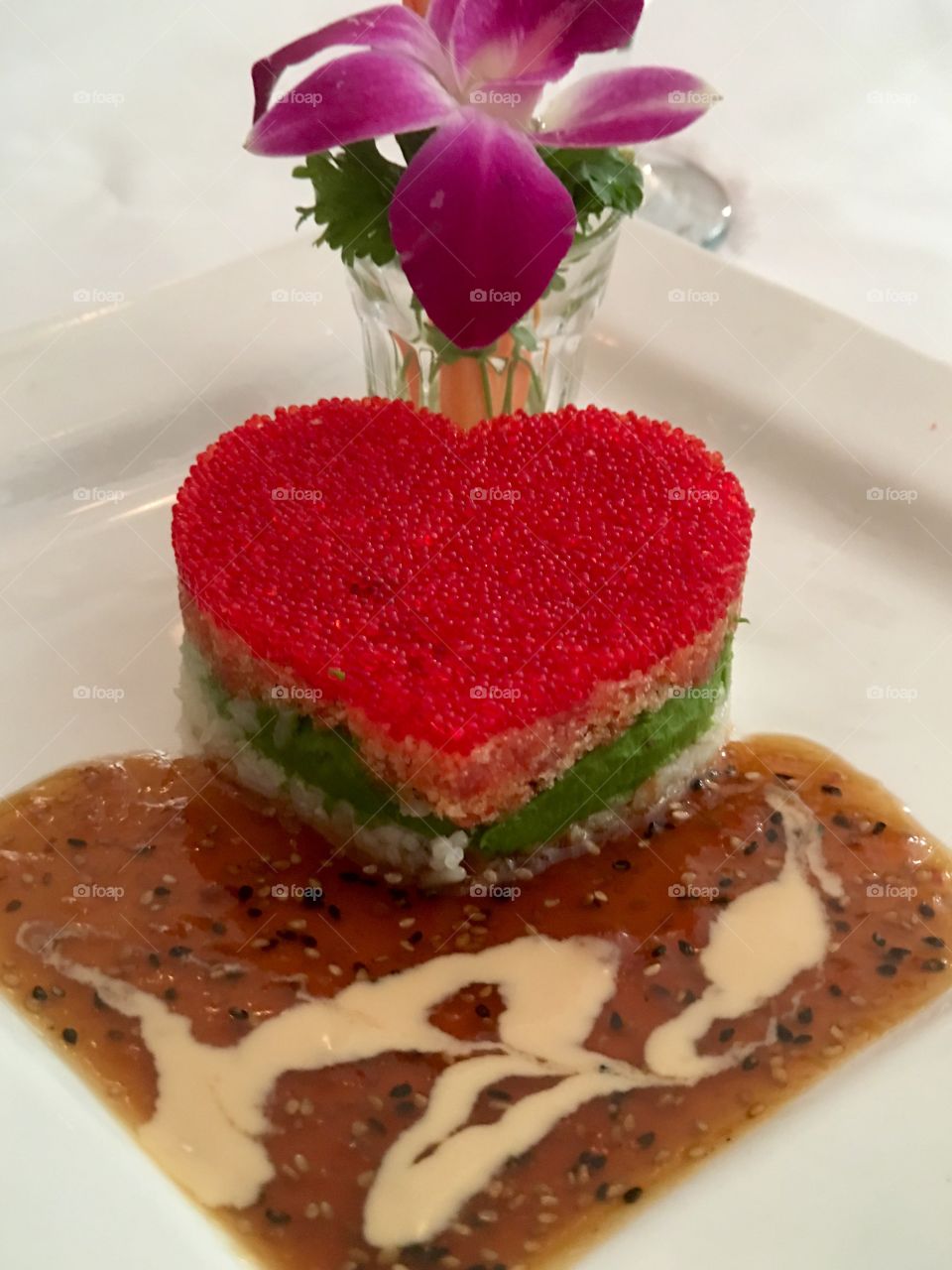 Japanese sushi; heart shaped red salmon row over sushi salmon artfully arranged on white plate