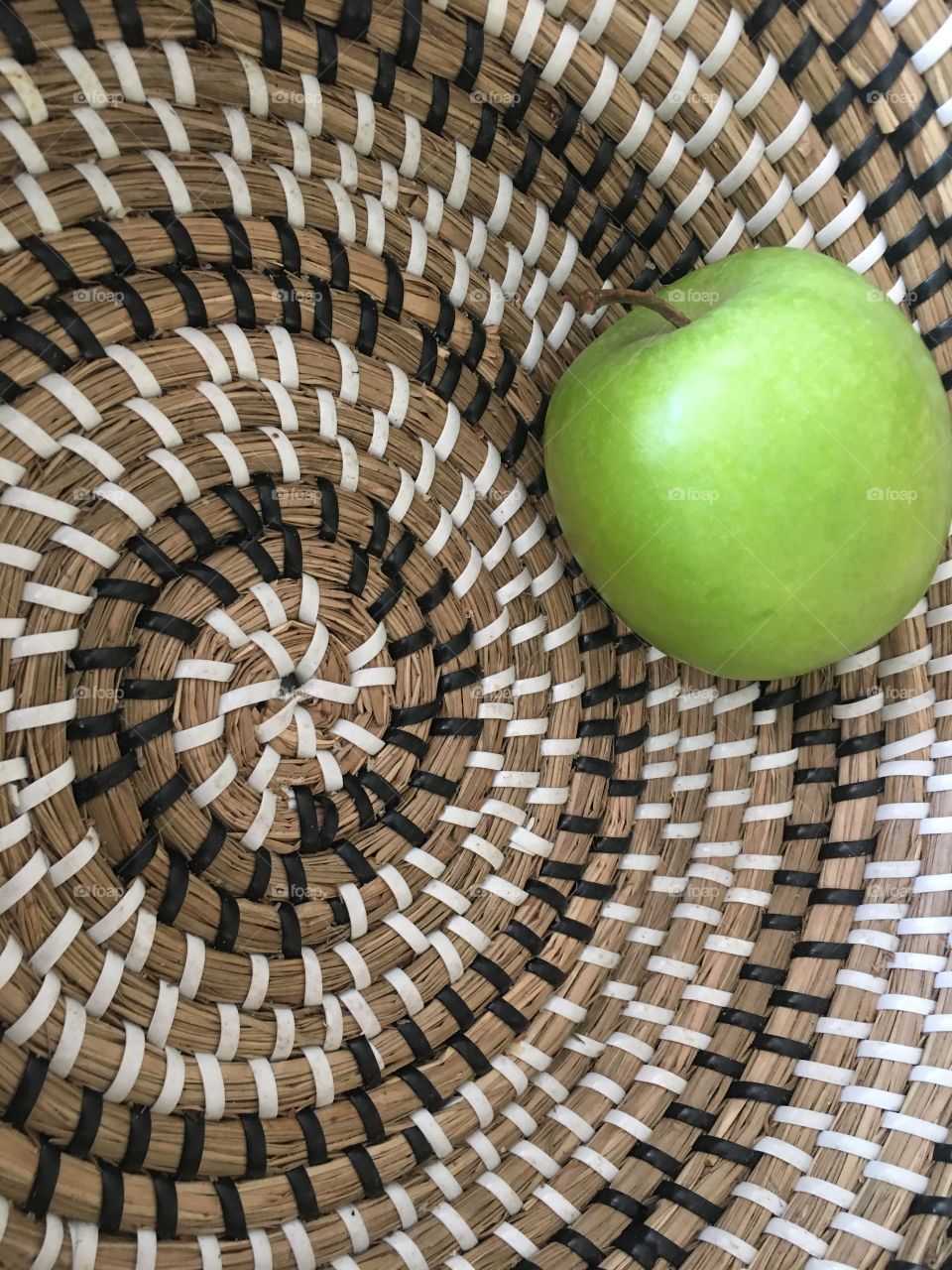 Fruit basket with a green apple inside
