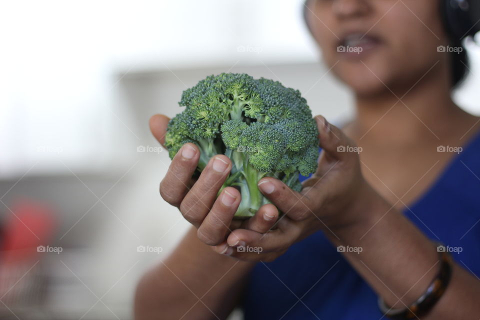 Young woman hand holding broccoli 