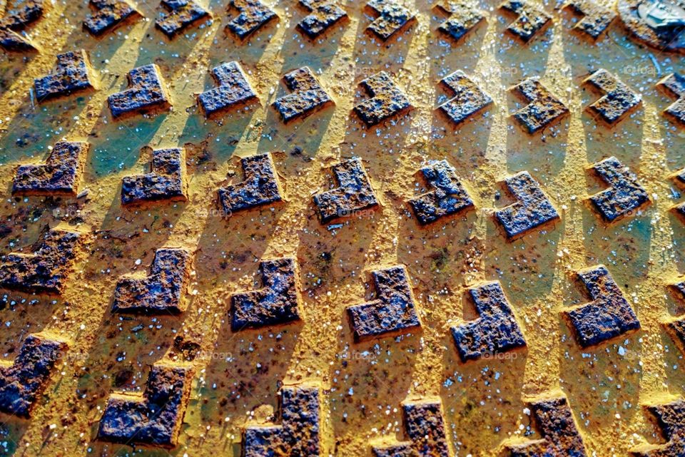 Rusted metal and concrete grate on walkway