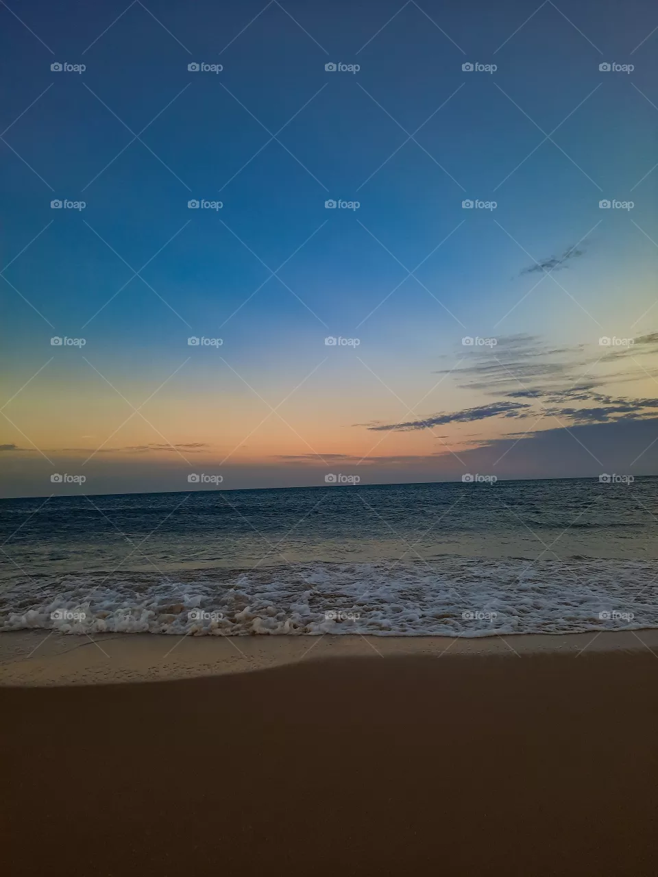 Perfect and calming view of a beautiful evening with sun setting in the horizon. Colours, clouds beautiful skies with clear waters and sand.