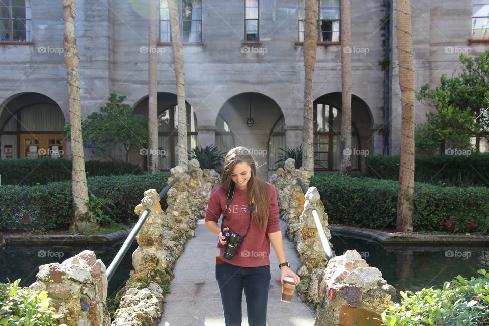 Young woman with camera in front of building