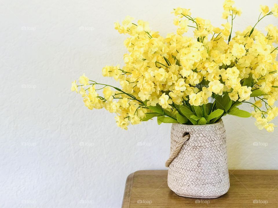 Bouquet of yellow flowers on the wood table inside the sanctuary of the day of rest. 