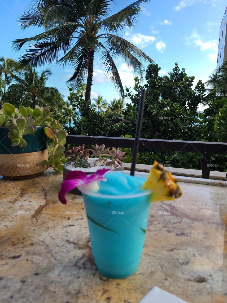 tropical blue drink in the background in hawaii with palm trees