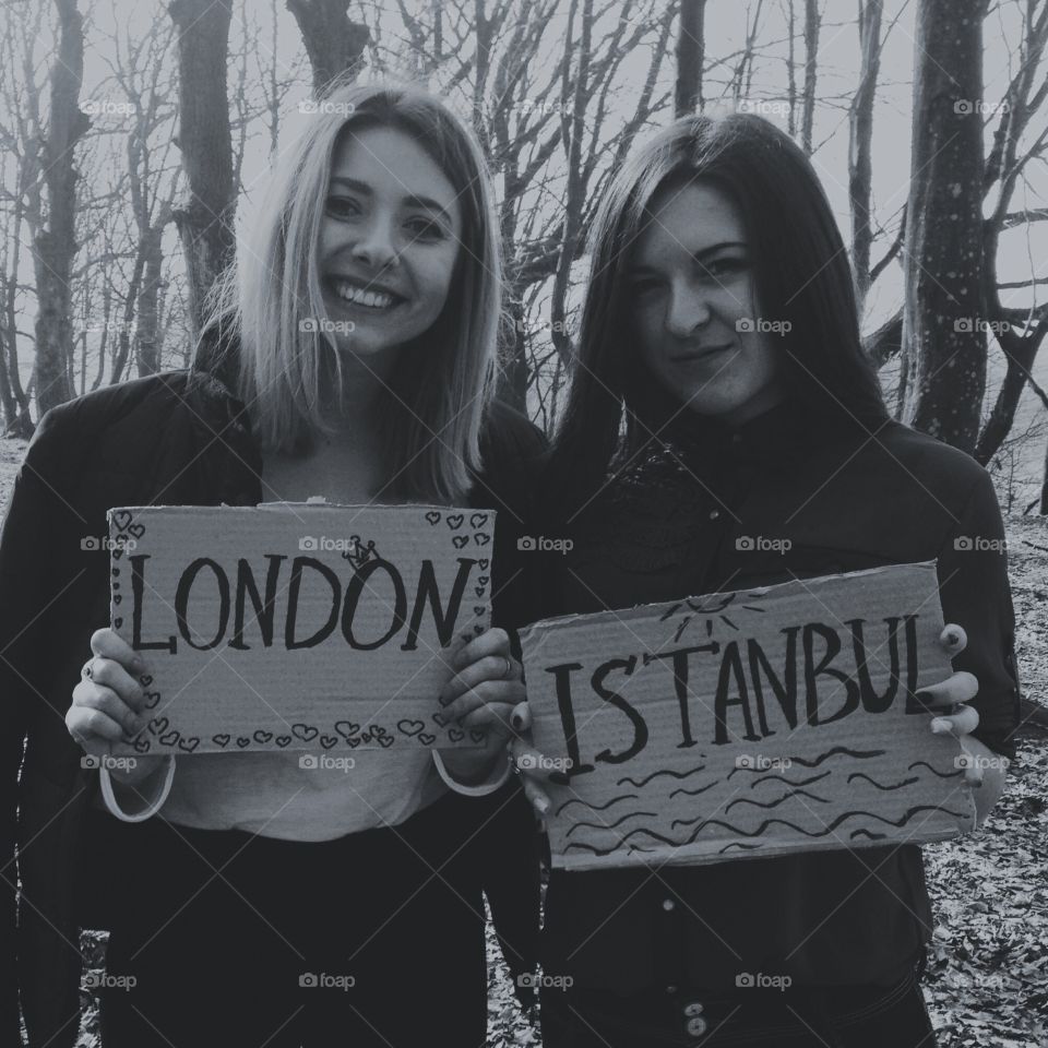 Two women holding cardboard with london and istanbul text