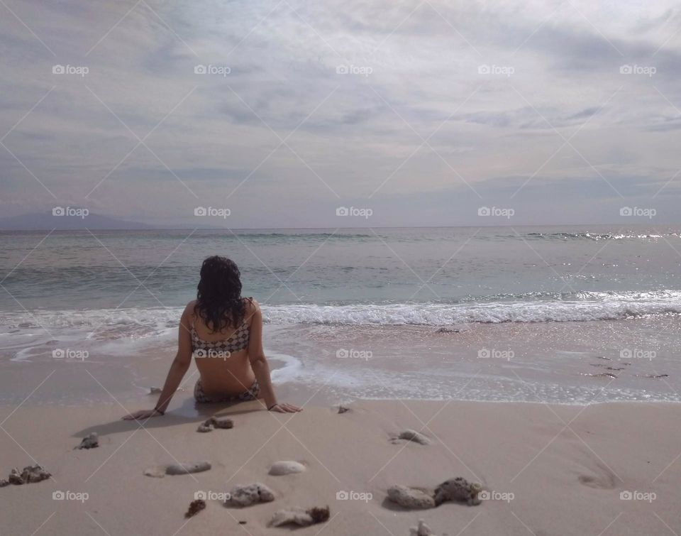 A girl at the beach on a cloudy hot day