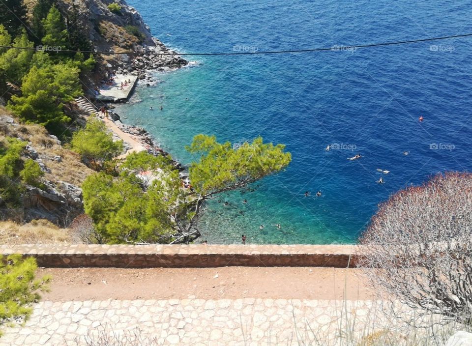 A capture above an isolated beach in Hydra, accessible only by foot. It's a beautiful little beach surrounded by trees with deep water.