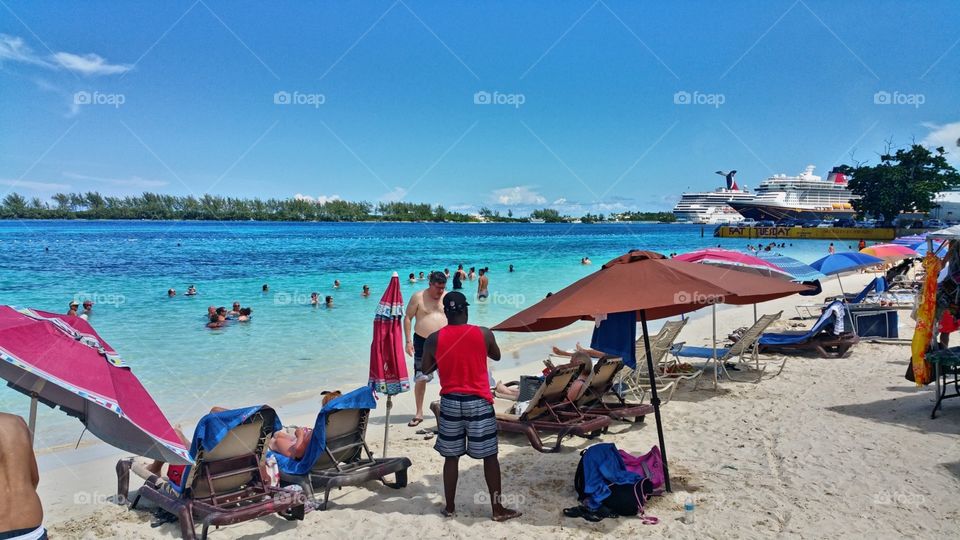 People at Junkanoo beach Enjoying the day😎 Nassau Bahamas..Cruise ships in the distance🚢