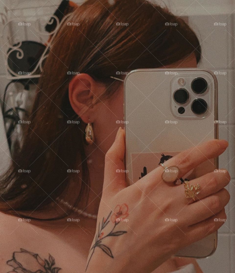 A girl with earrings in her ears and rings on her fingers without a face