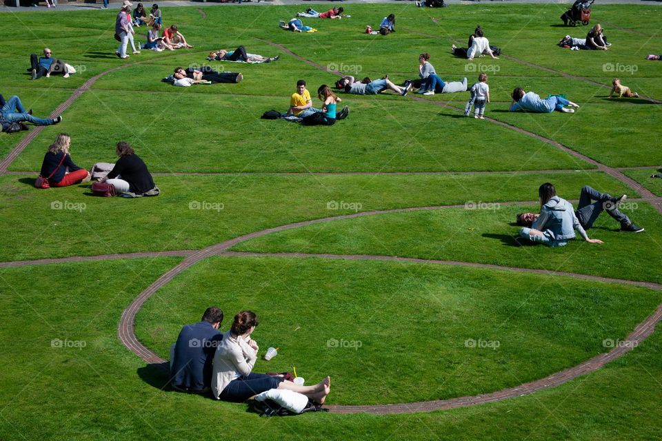 People enjoying a summer day on the grass in a city park 