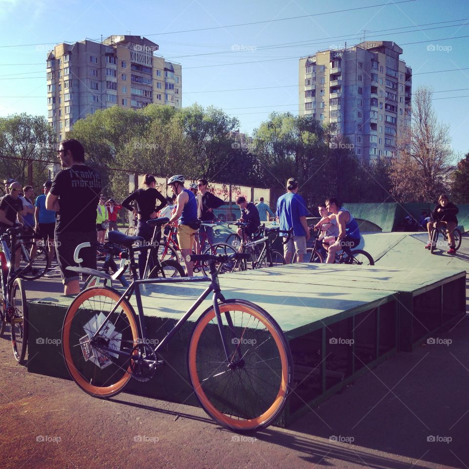 Grey brakeless fixie bike with orange wheels standing on one of the streets of Tver city, Russia