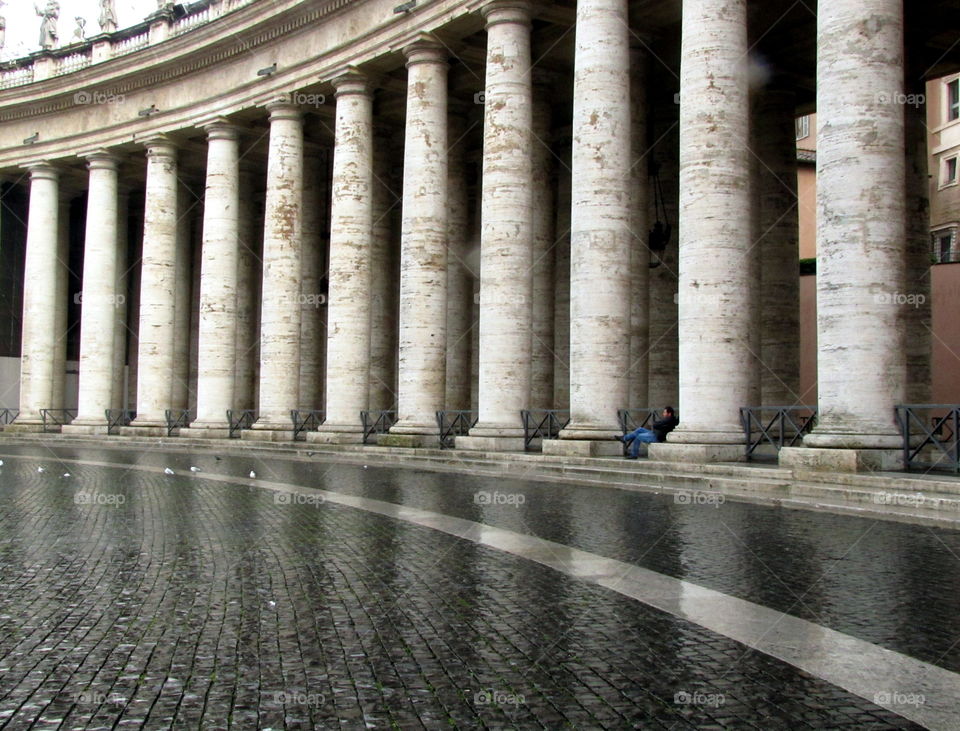 reflections of the colonade on the pavement bathed by the rain