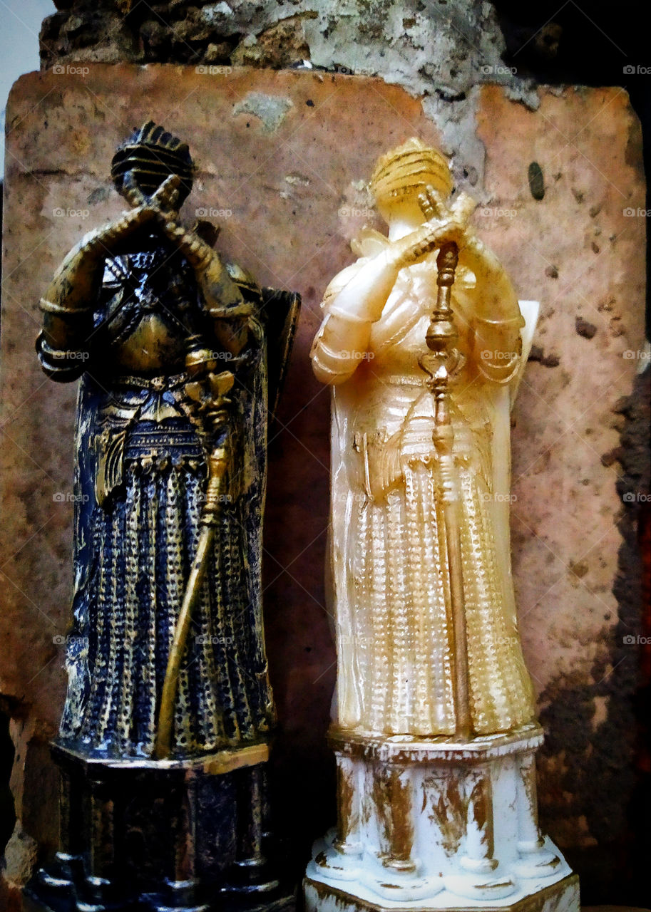 Chess.  Two figures of queens on a brick wall background