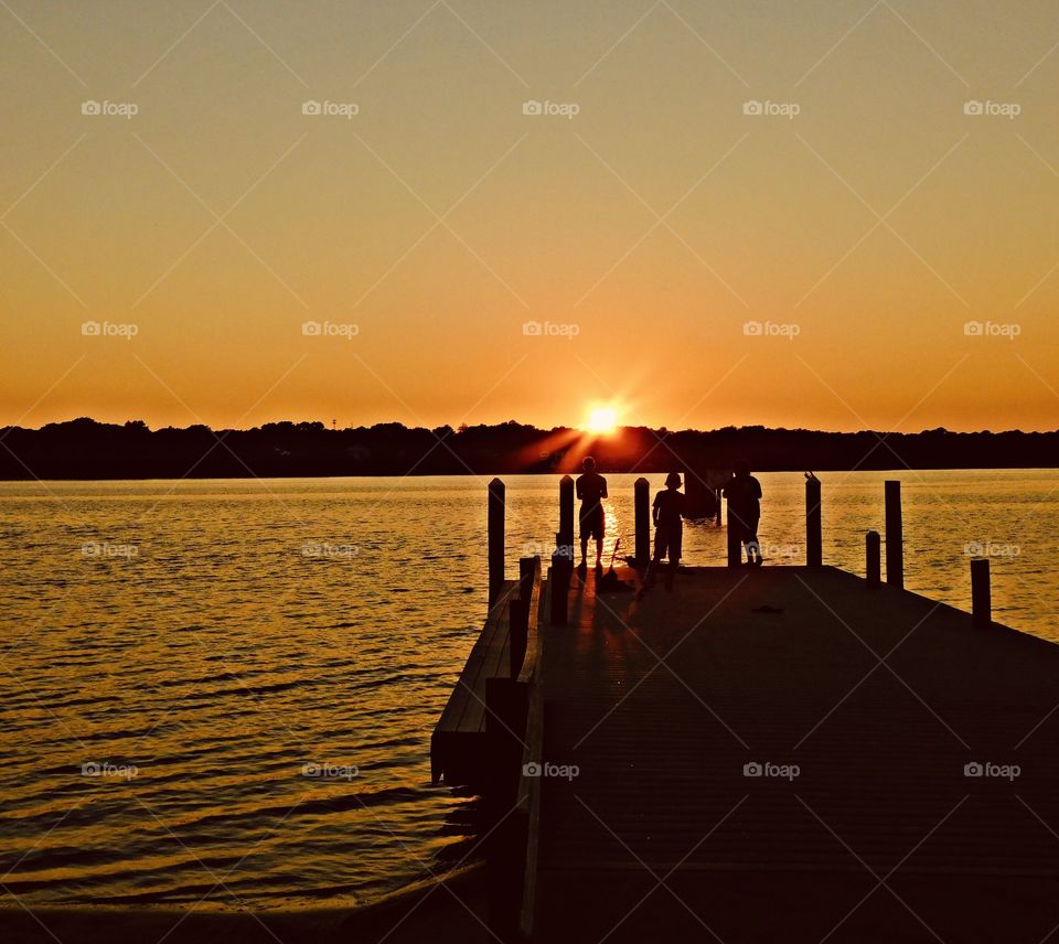 Sunrise and sunsets of USA - family fishing on pier in the sunset