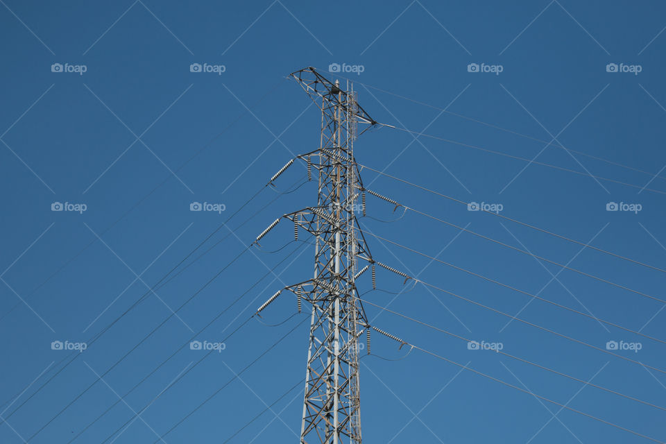 High voltage electricity pole with clear blue sky background 