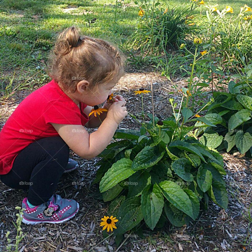 Even a busy 2 yr old takes time to stop and smell the flowers!