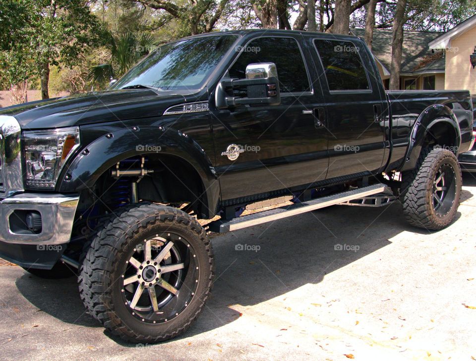 Black 350 Ford Power stroke with chrome galore. Chrome bumper, lifter, step up, and sway bars. Huge tires on chrome rims. 