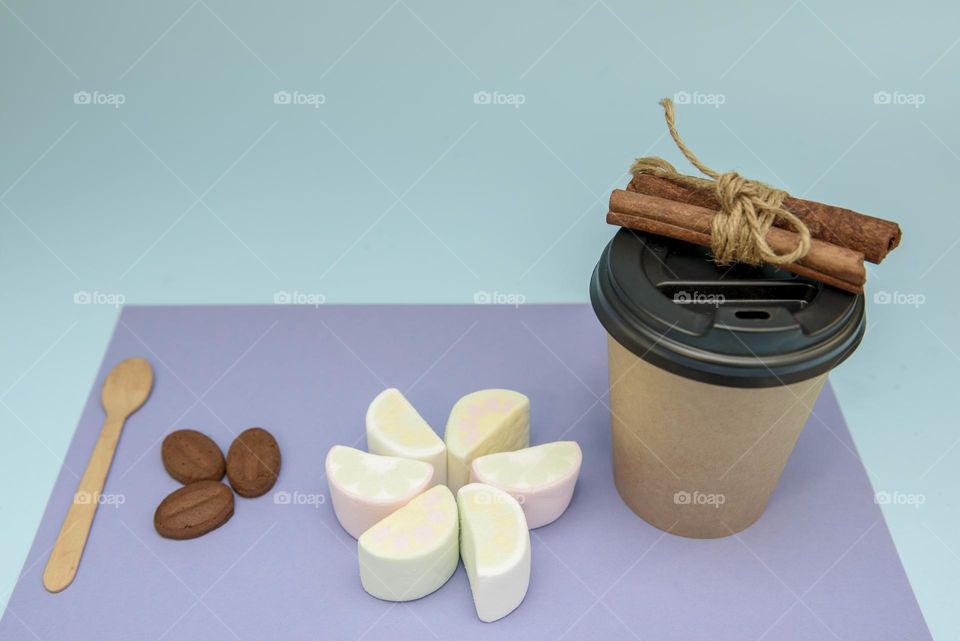 Coffee paper cup and sweets on a colorful background. Cafe background template and creative concept