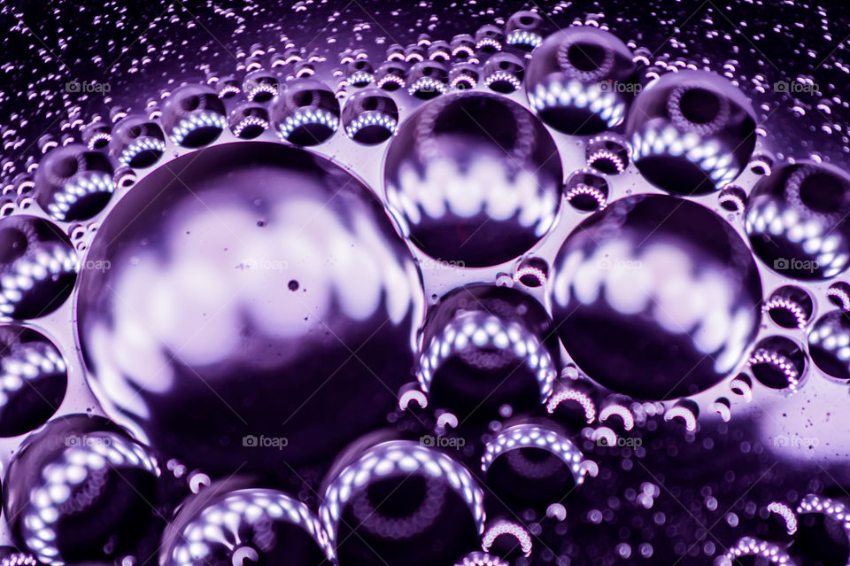 Small bubbles of vegetable oil in water close-up.