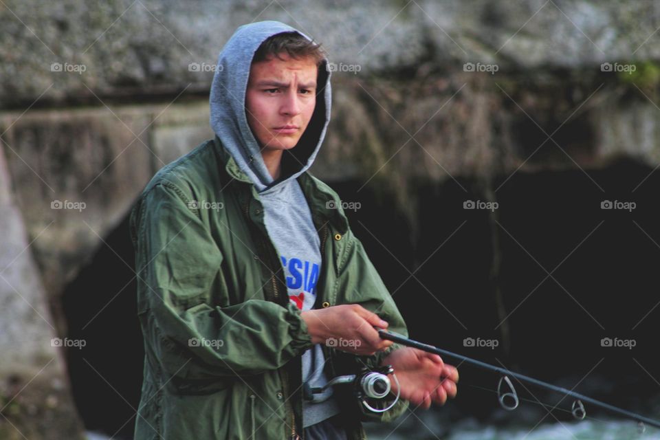 young man in a hood on a fishing trip. portrait.