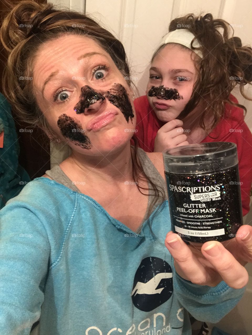 A mother and daughter being silly during an in home spa night. 
