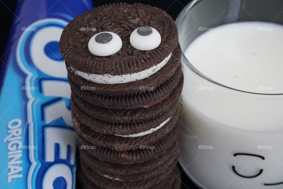 Oreo Cookie Monster Stack With goggly eyes and a packet of biscuits in the background and a glass of milk.  Yummy 😋