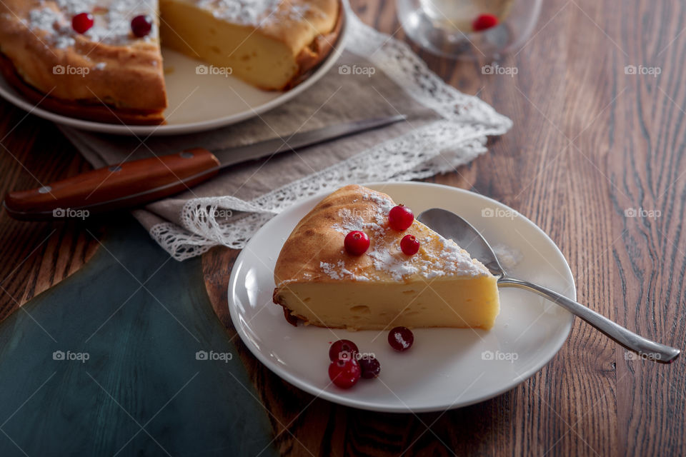 Cheesecake with cranberries and sugar on wooden background